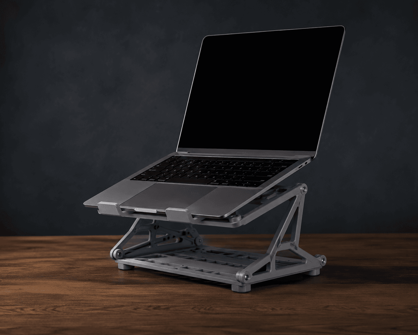 A laptop resting on a 3D printed adjustable stand in a controlled product shot.