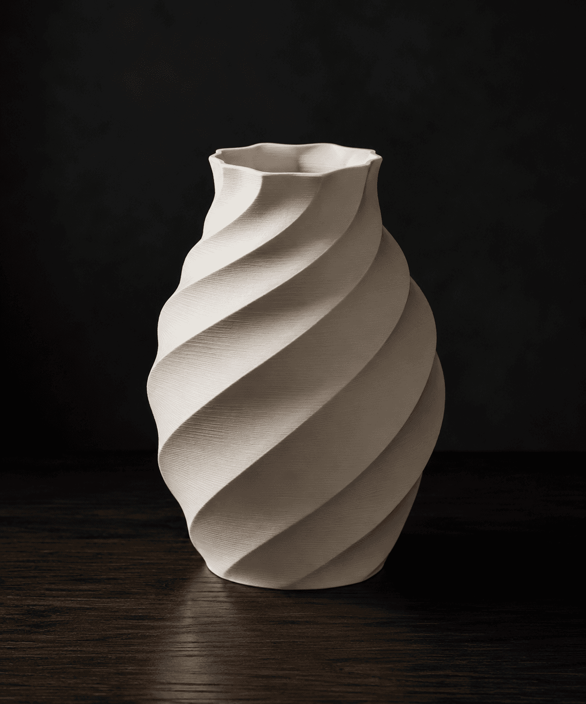 A sculptural off-white 3D printed vase photographed on a dark wooden surface.